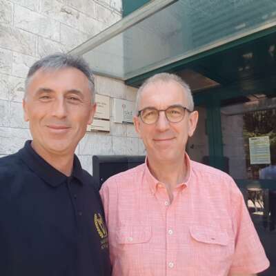 Two men engaged in a conversation, wearing casual attire